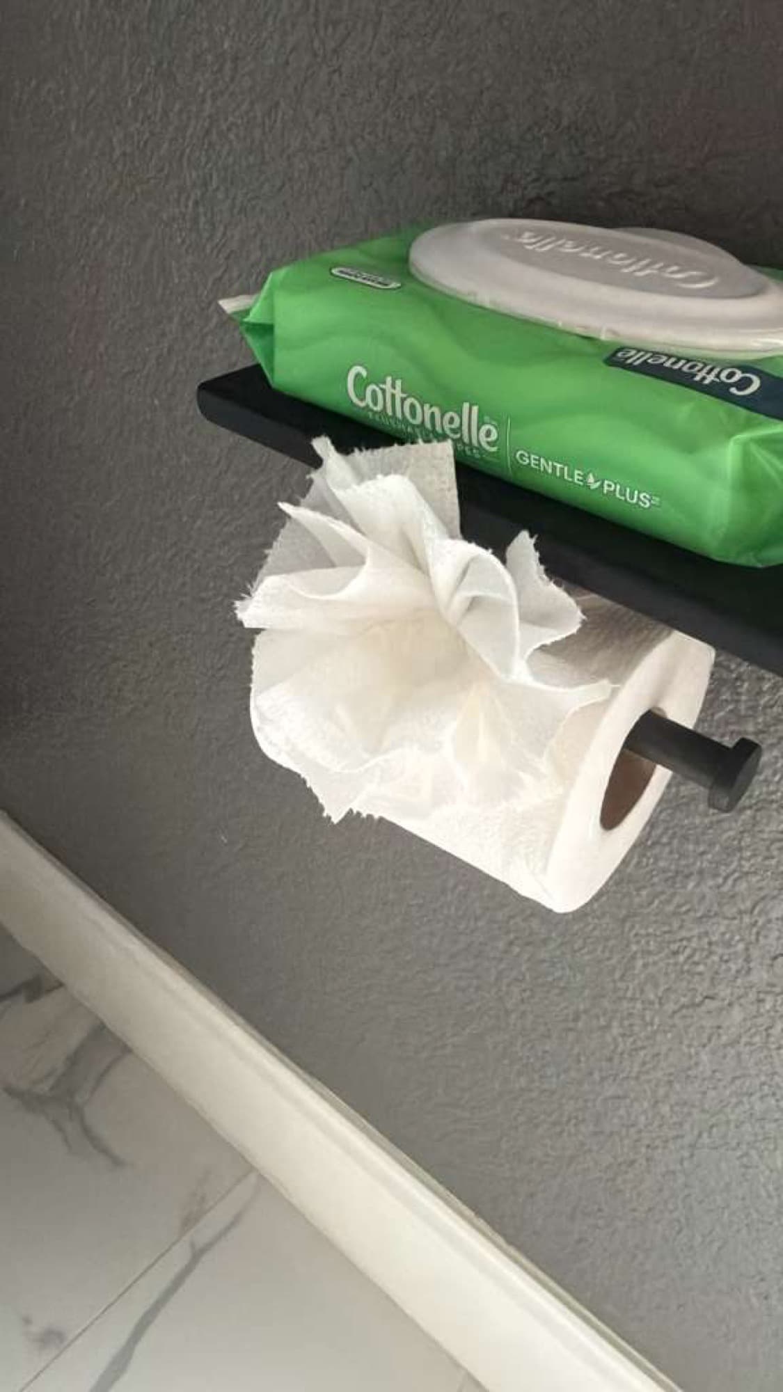 Toilet paper and wipes arranged neatly in a clean bathroom.