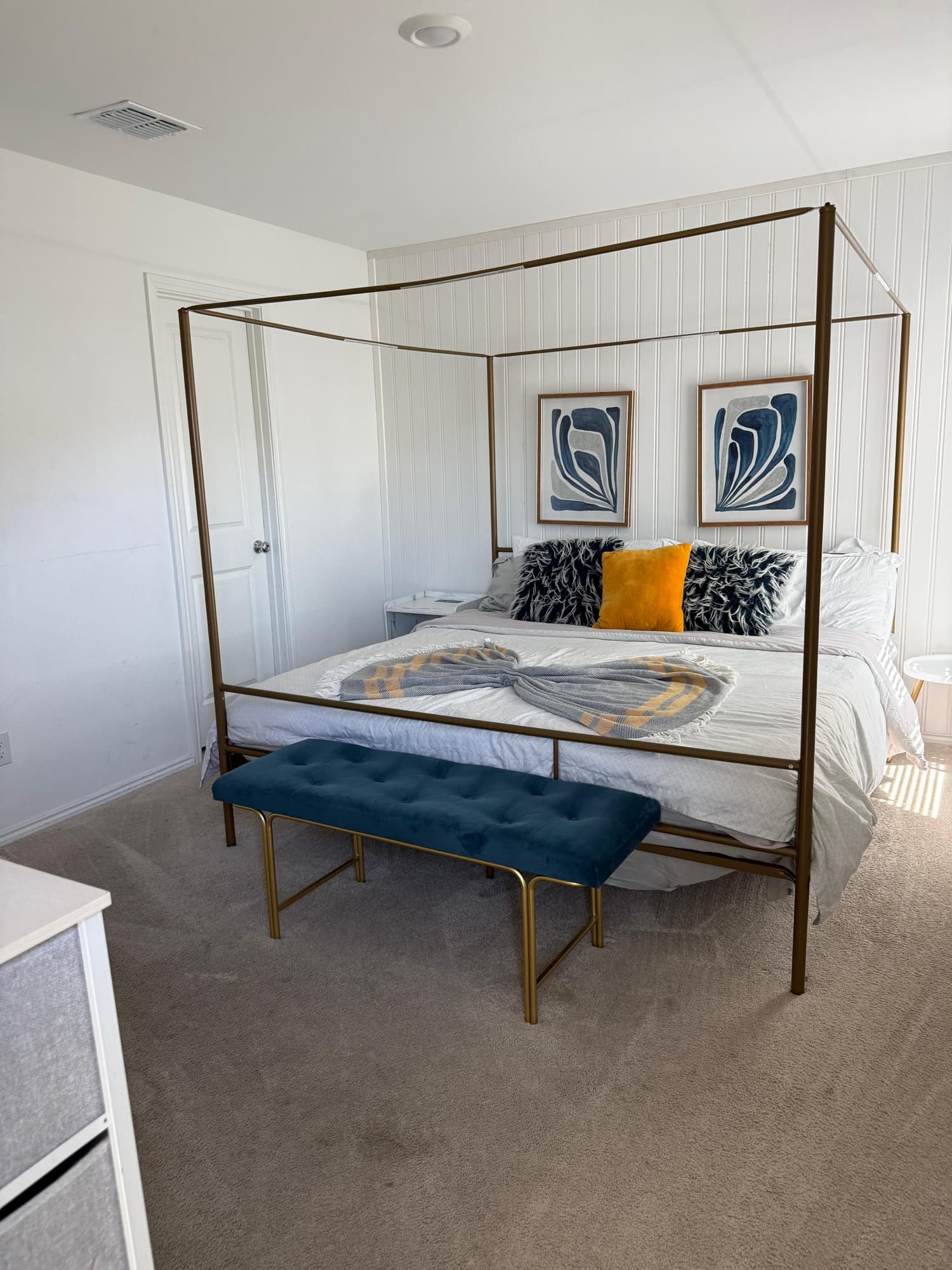 Clean canopy bed with fresh white bedding and decorative pillows.