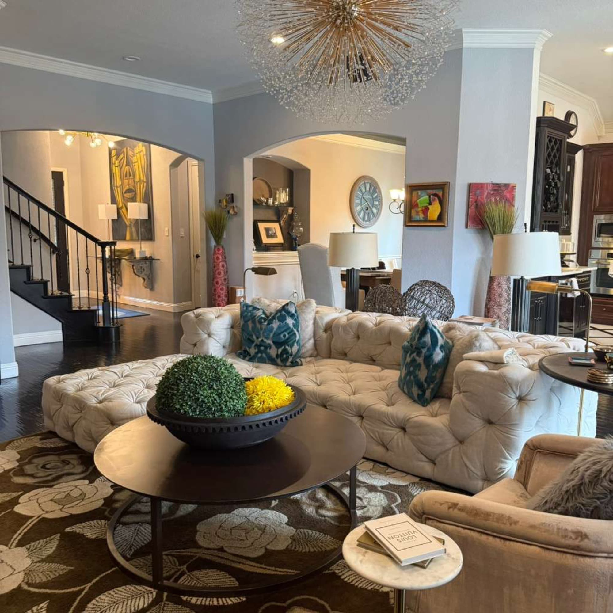 Elegant living room with tufted sectional, clean surfaces, and decor.
